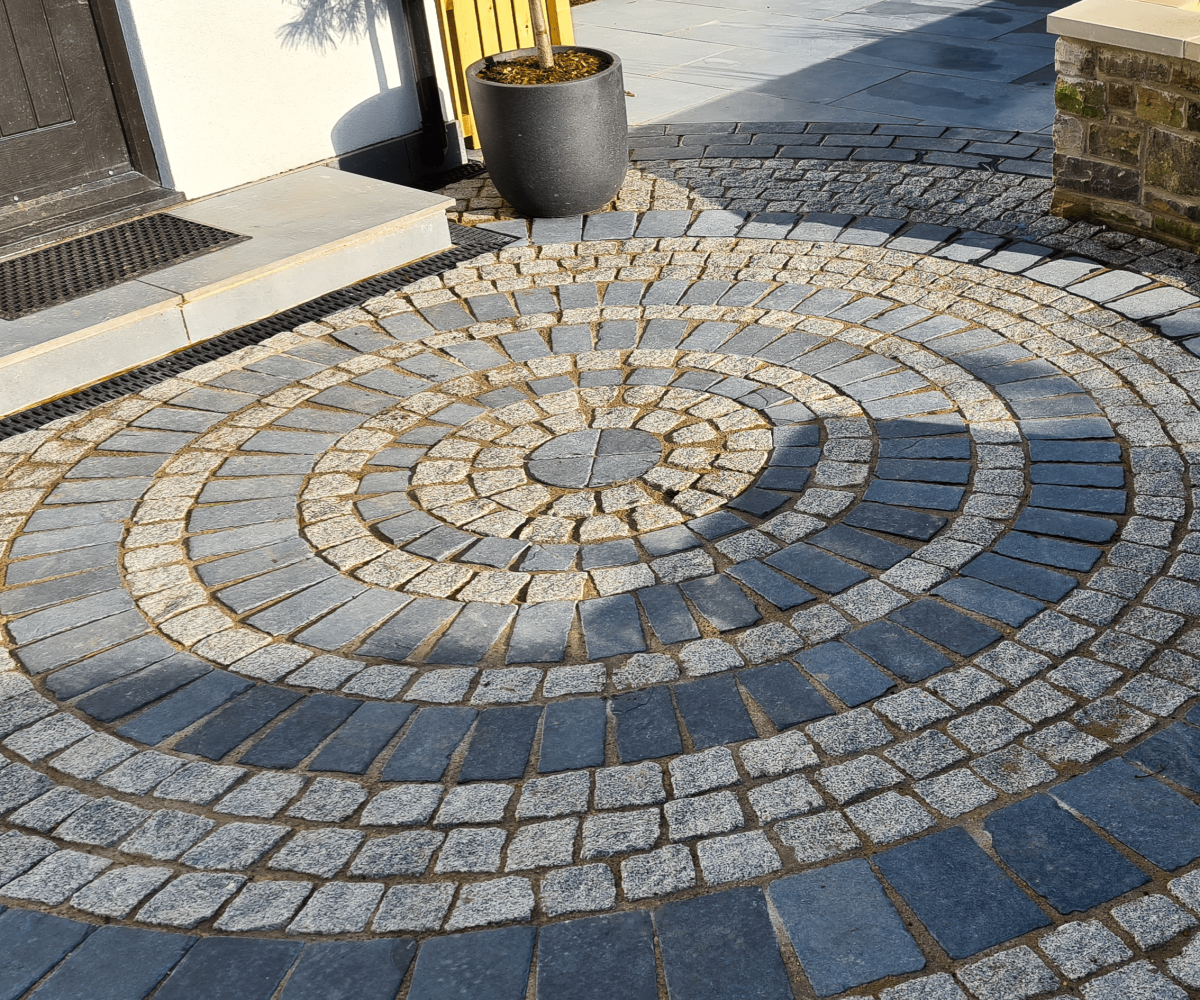 Natural-Paving-Granite-Silver-Setts-Circular-Driveway-Feature-with-Ebony-Cobblestone.png